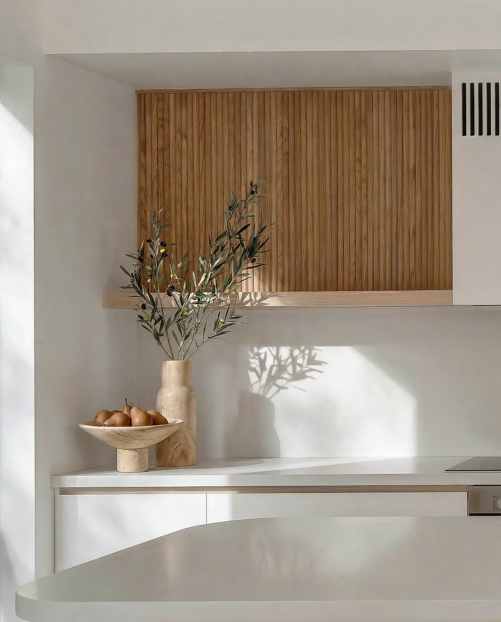 Kitchen joinery in American oak with white stone benchtop and olive branch styling.