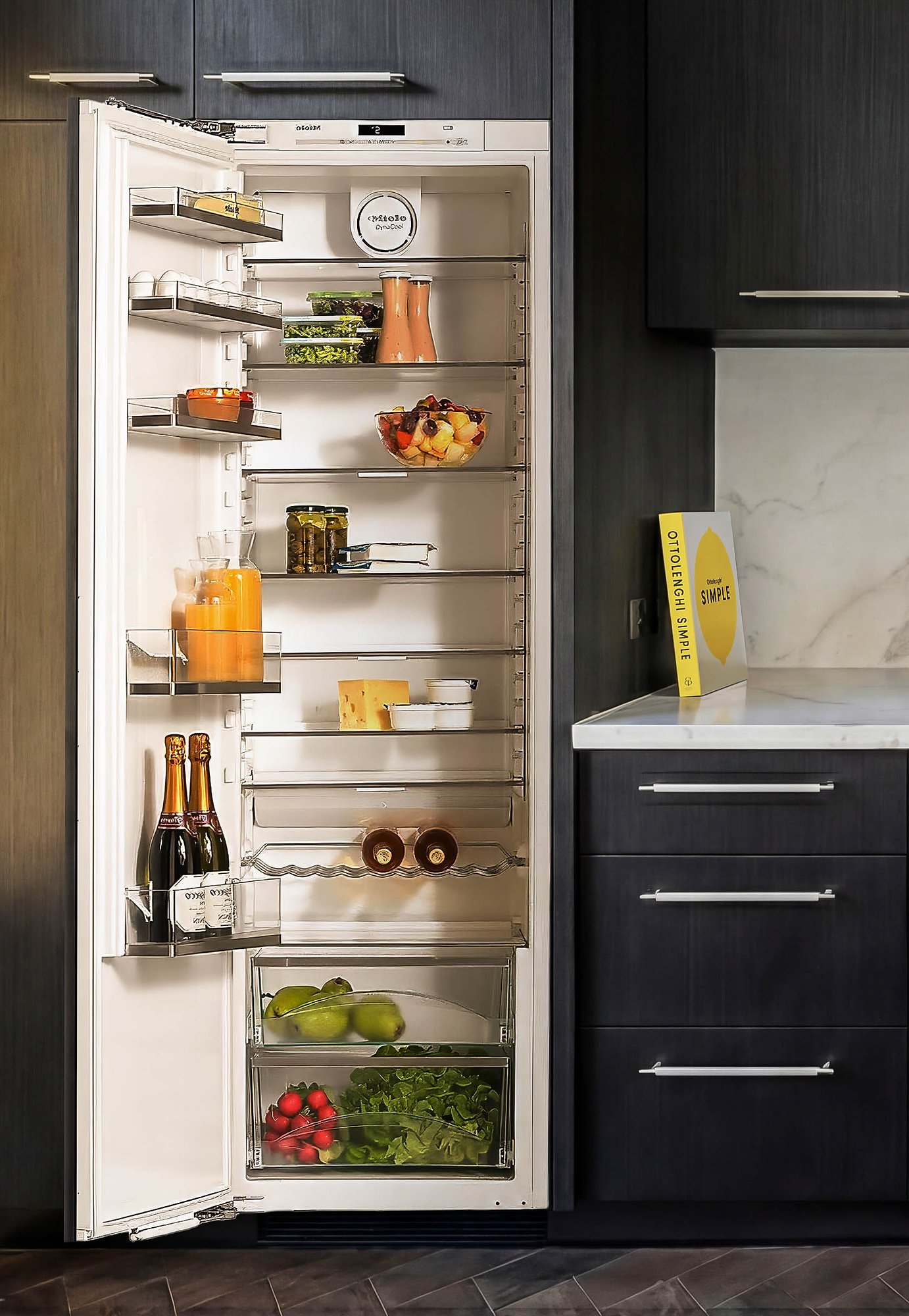 Built-in refrigerator with timber shelving and dark oak cabinetry in architecturally designed kitchen.
